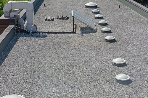 Crew installing a reinforced PVC single-ply membrane on a DFW commercial roof